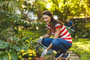 Smiling caucasian man and woman working in garden wearing gloves